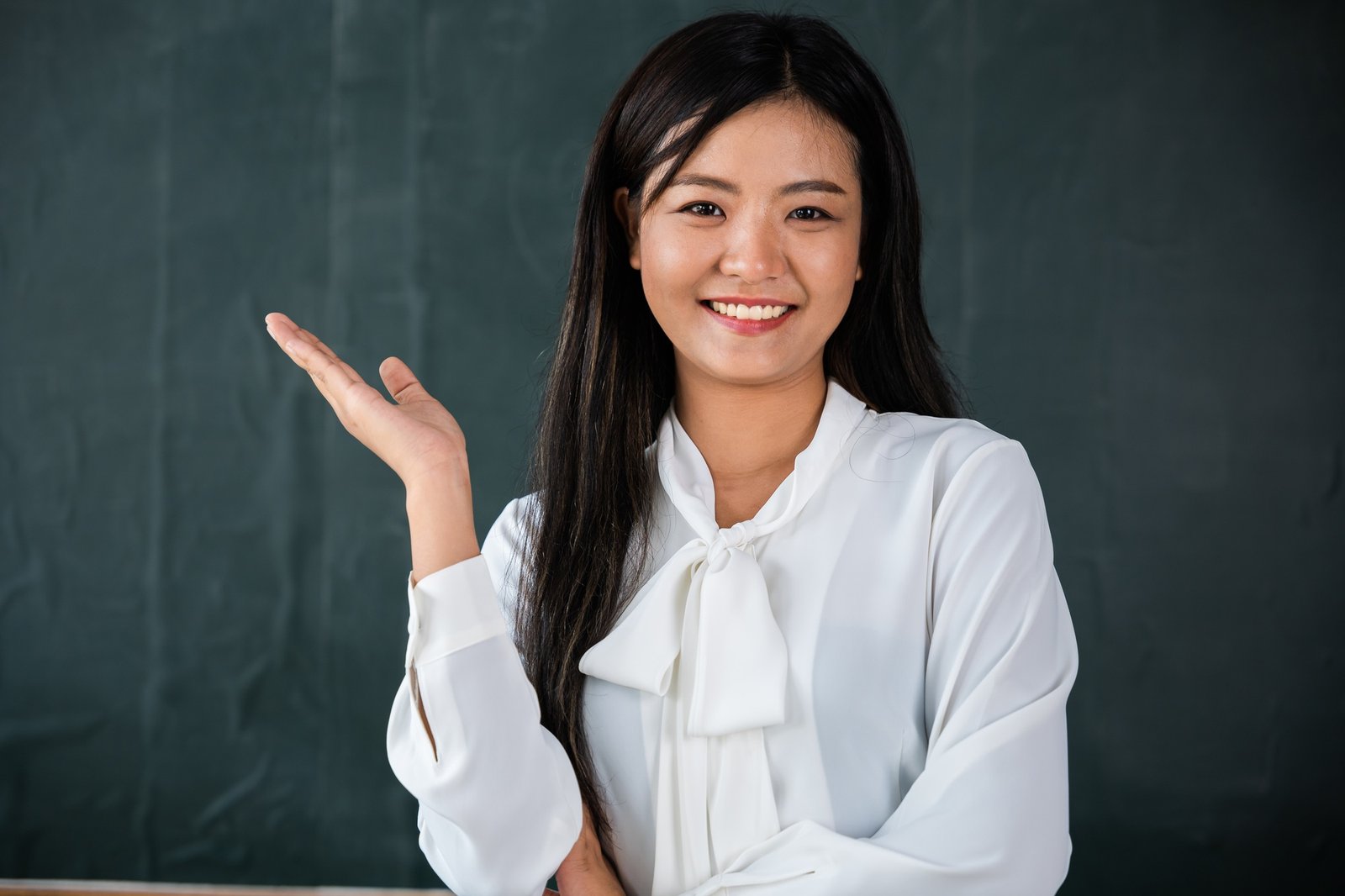 A woman is smiling and pointing her hand up